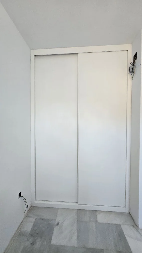 Frente cerrado de dos puertas correderas lacadas en blanco