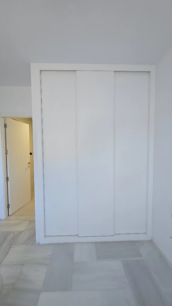 Armario de tres puertas correderas blancas de hoja entera
